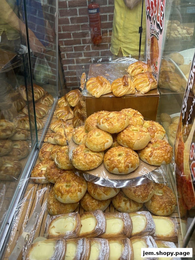 A display of freshly baked pastries, including croissants and danishes, in a bakery.
