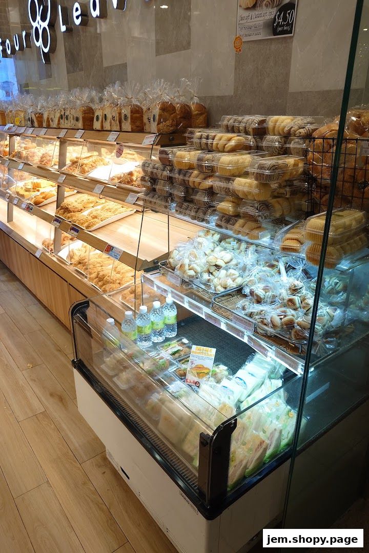 A display of freshly baked bread, pastries, and sandwiches in a bakery.