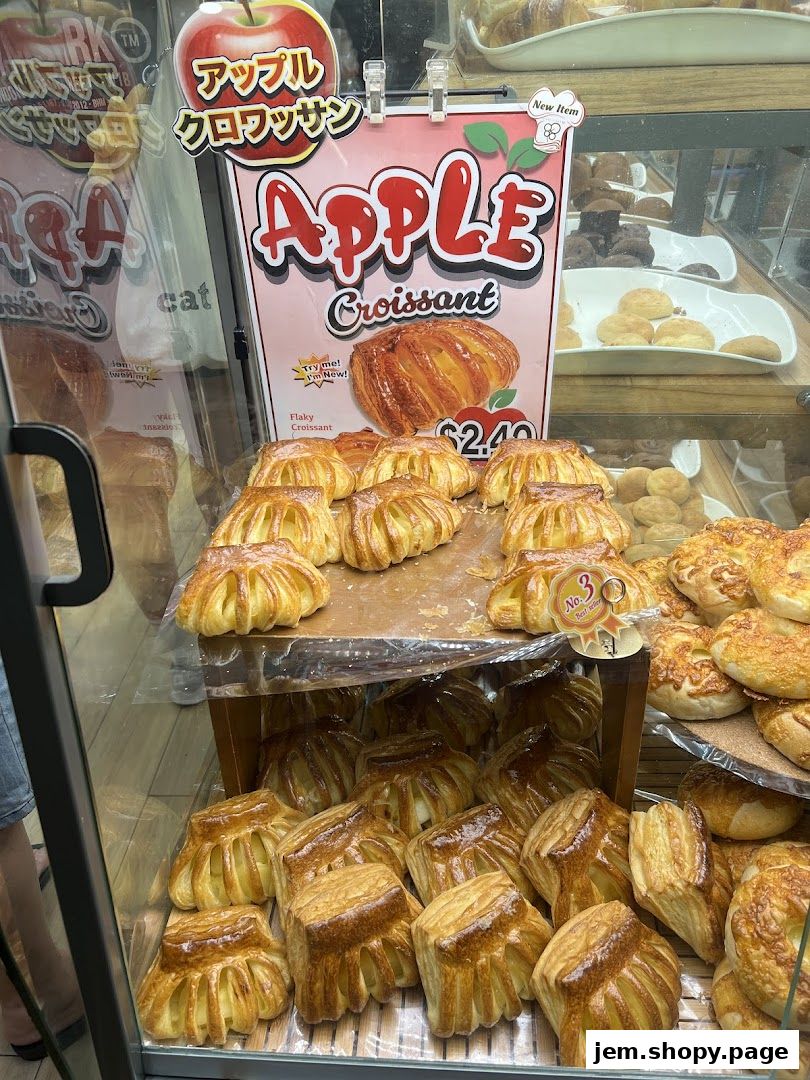 A display of freshly baked apple croissants and other pastries at a bakery.