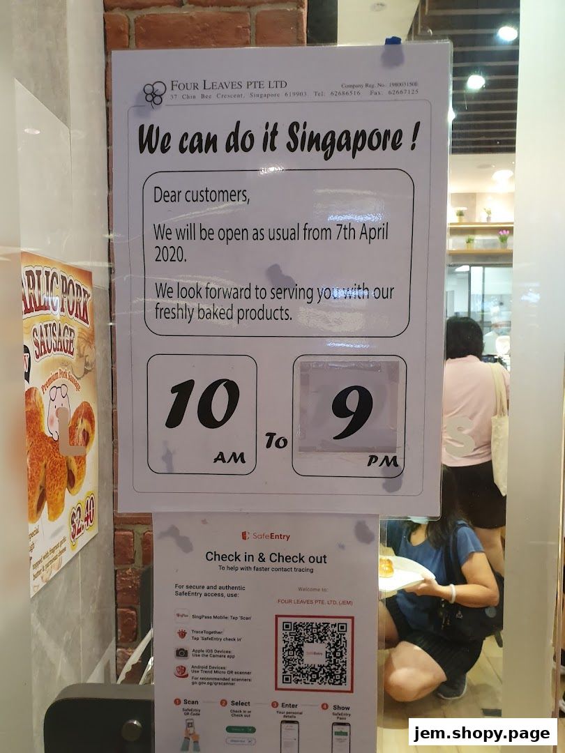 A sign announcing Four Leaves bakery will be open as usual with operating hours.