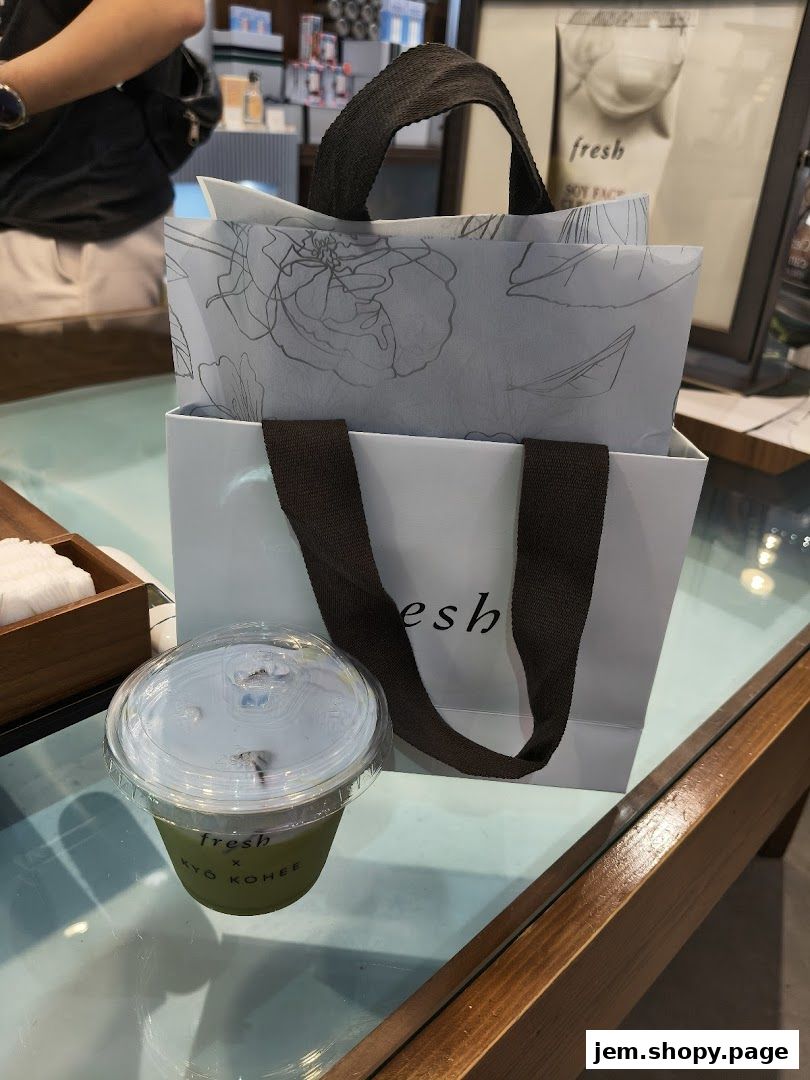 A branded shopping bag and a drink from Fresh, possibly a collaboration.