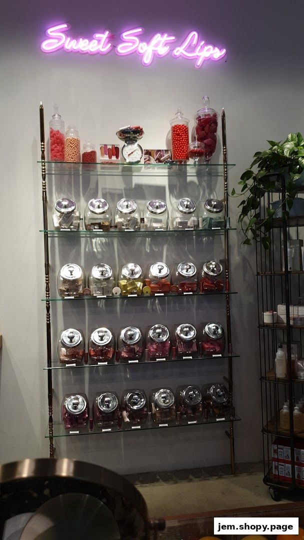 A shop interior with shelves displaying jars of lipsticks and candies under a neon sign.