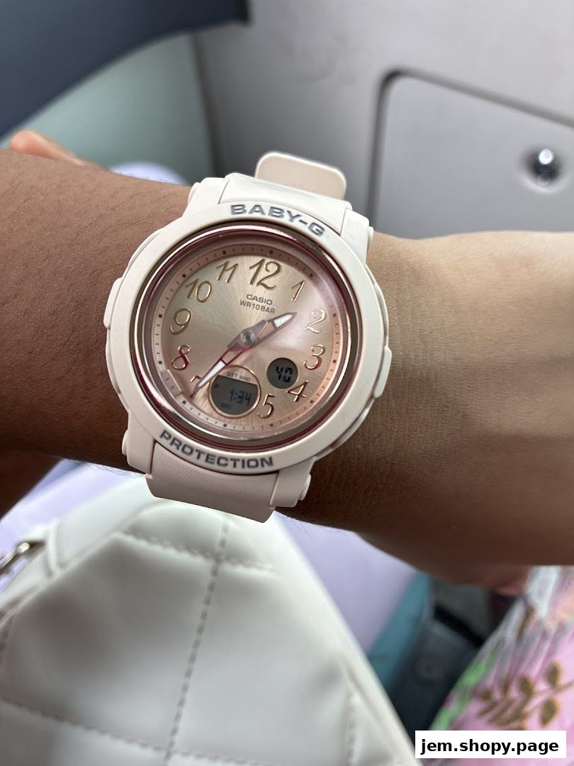 A person wears a white Baby-G Casio watch with a rose gold dial.
