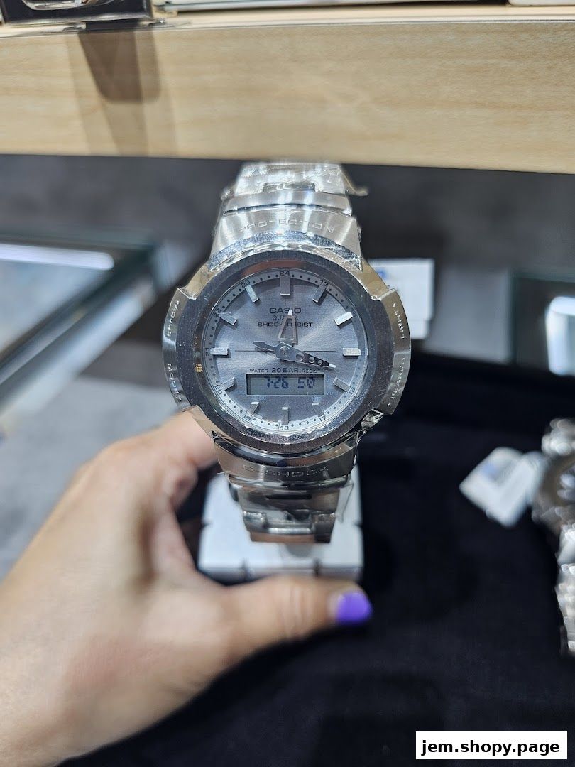 A close-up of a silver G-SHOCK CASIO watch with a digital display.