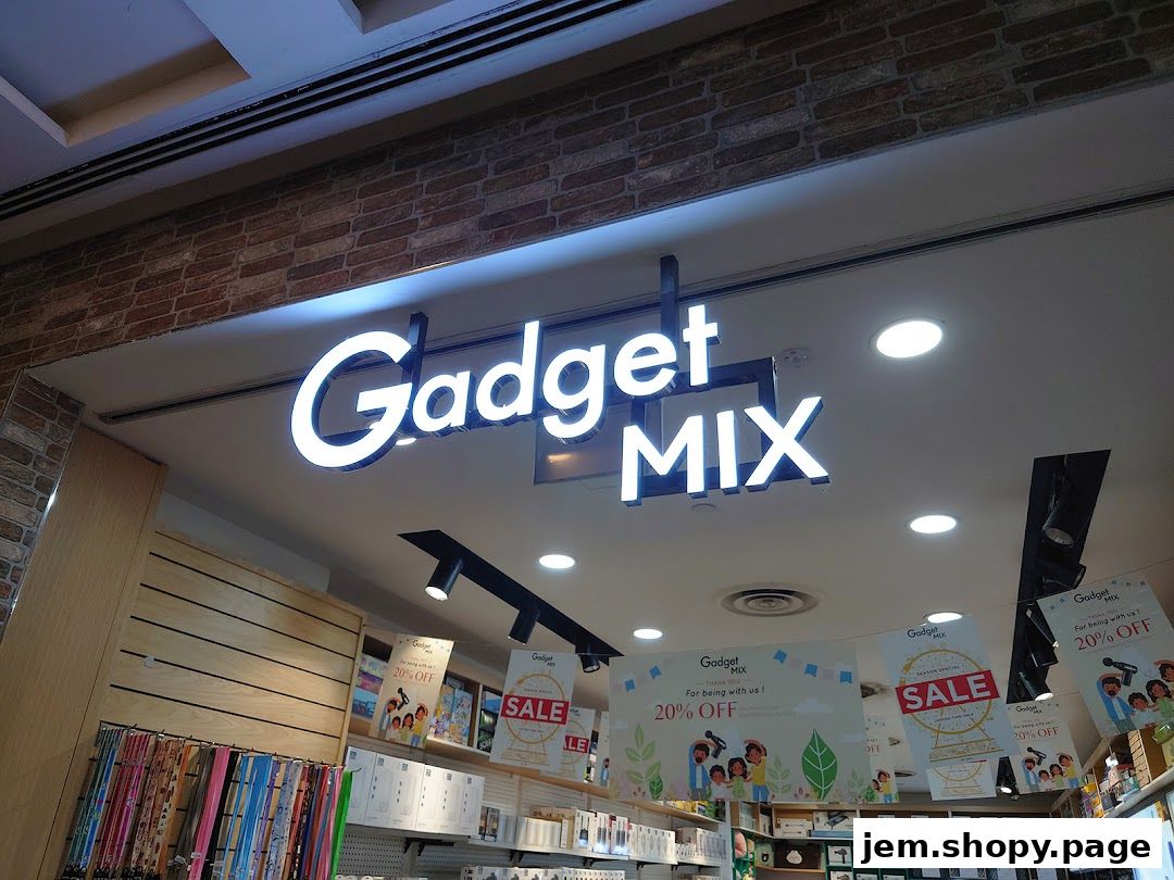 The illuminated sign for 'Gadget Mix' above a retail store interior with sale posters.