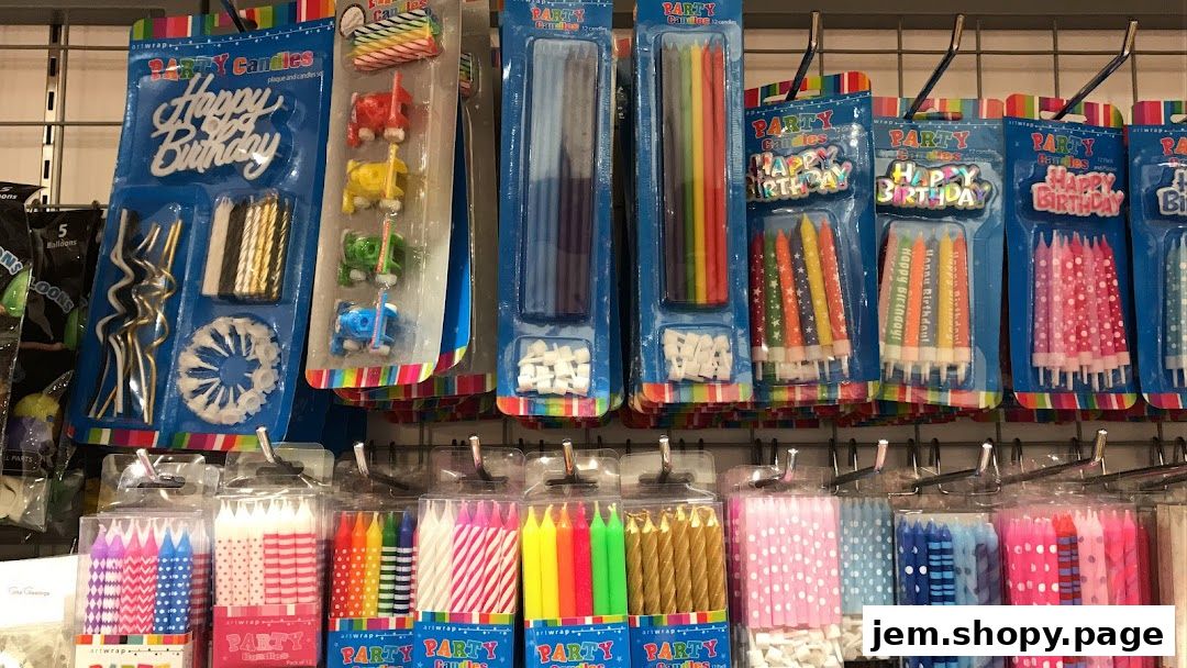 A display of various birthday candles and party supplies, including 'Happy Birthday' toppers.