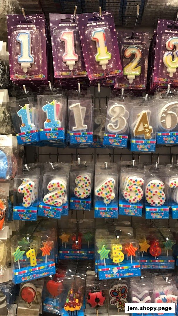 A display of various numbered and shaped birthday candles in packaging.