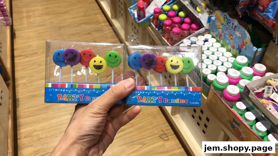 A hand holds two packages of smiley face party candles in a gift shop.