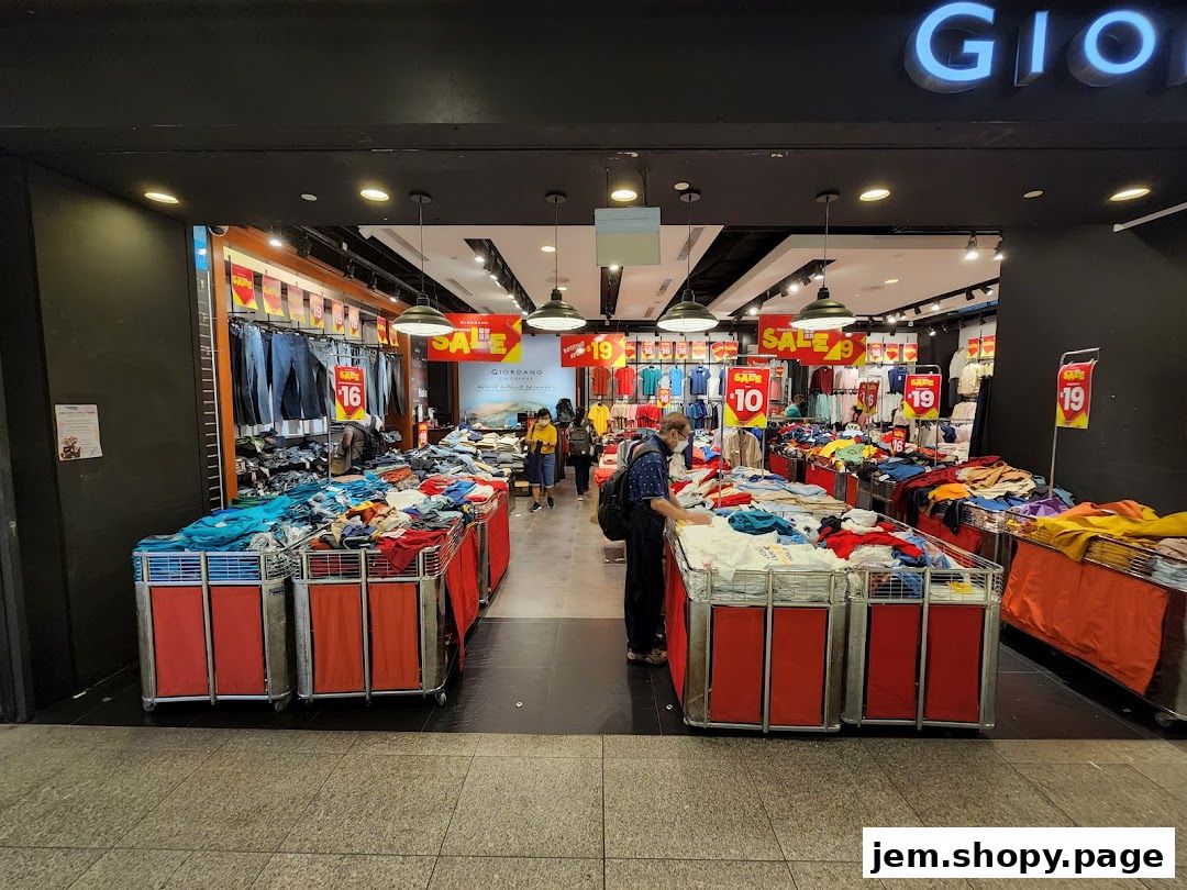 Giordano shop entrance with racks of clothing and sale signs.