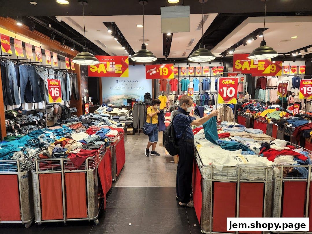 Customers browse discounted clothing in a Giordano store during a sale event.