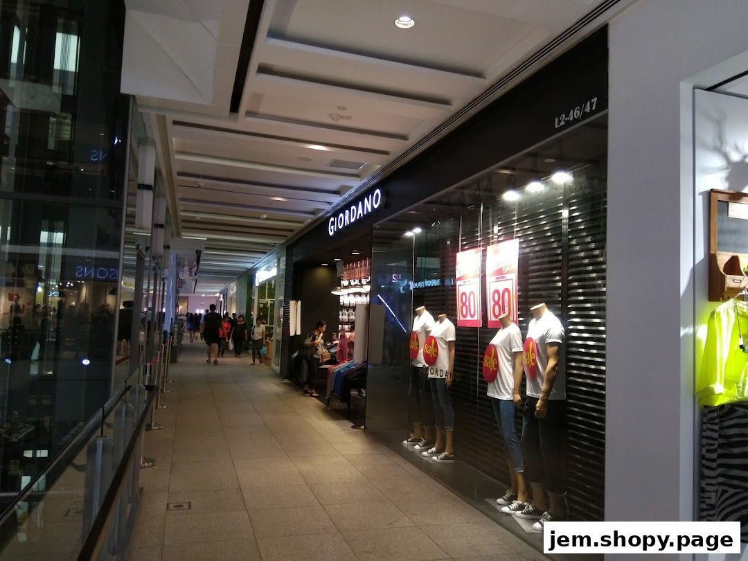 Giordano shop front with mannequins displaying sale items in a mall walkway.