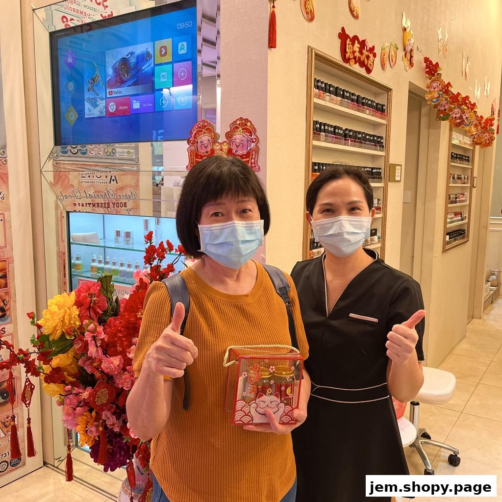 Two women in masks give thumbs up in a beauty studio with nail polish displays.