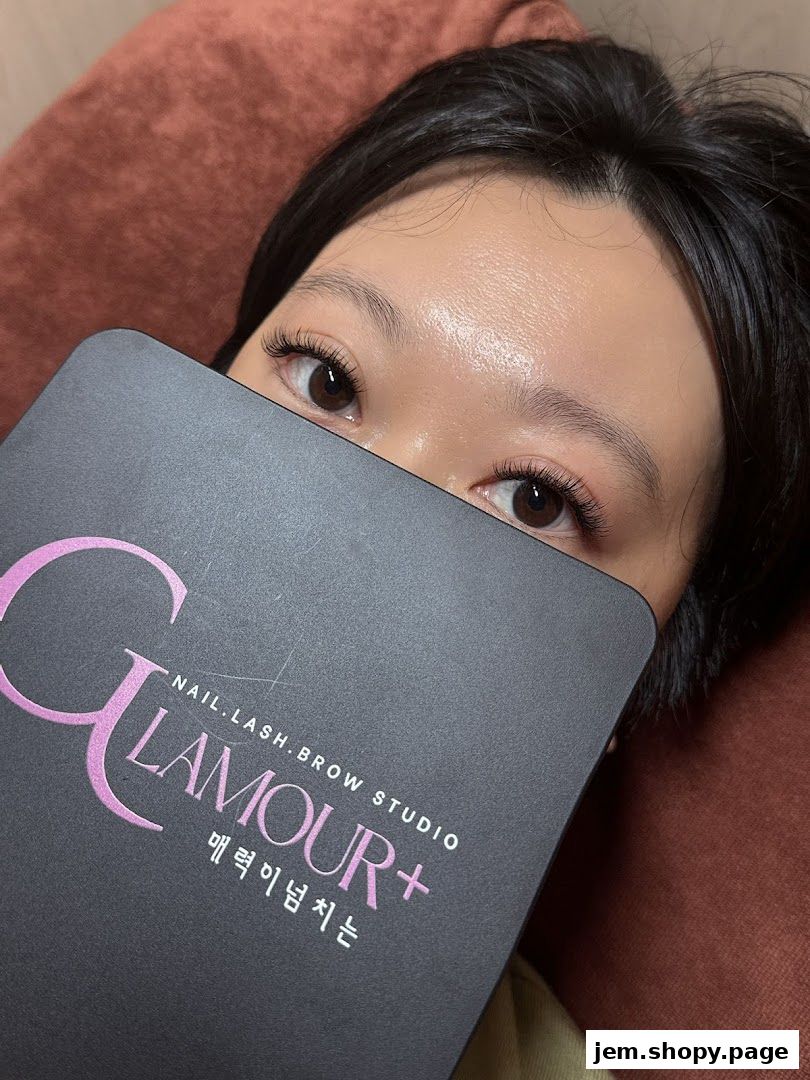 A close-up of a person's eyes and lashes, holding a Glamour Brow Lash Nail Studio card.