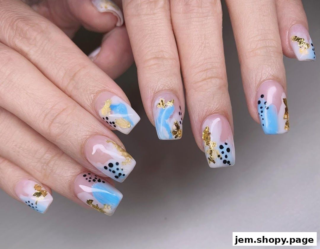 Close-up of hands with stylish abstract nail art featuring blue, gold, and black accents.