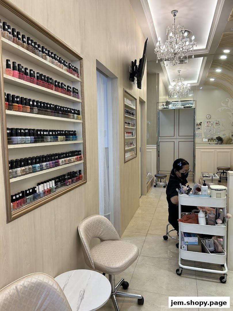 Interior of a nail salon with shelves of nail polish and a technician working.