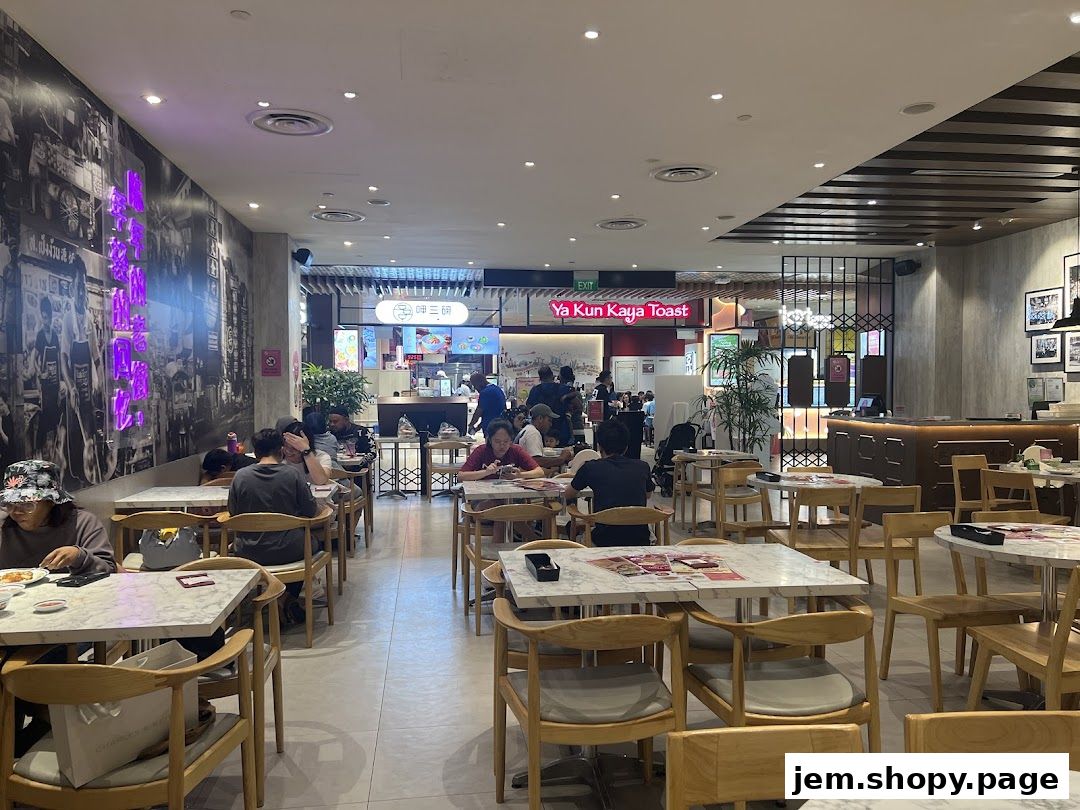 Interior view of a busy restaurant with diners seated at marble-topped tables.
