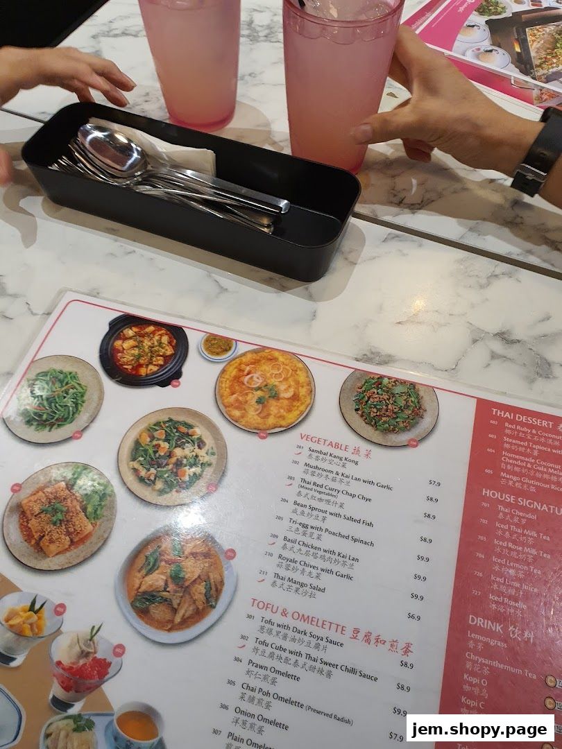 A menu with various Thai dishes, including vegetables, tofu, omelettes, and drinks.