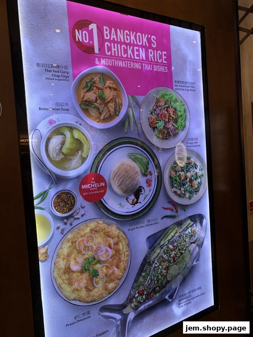 A brightly lit menu board showcasing various Thai dishes, including chicken rice and seafood.