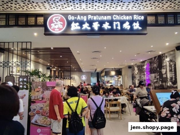 The entrance of Go-Ang Pratunam Chicken Rice restaurant with customers inside.