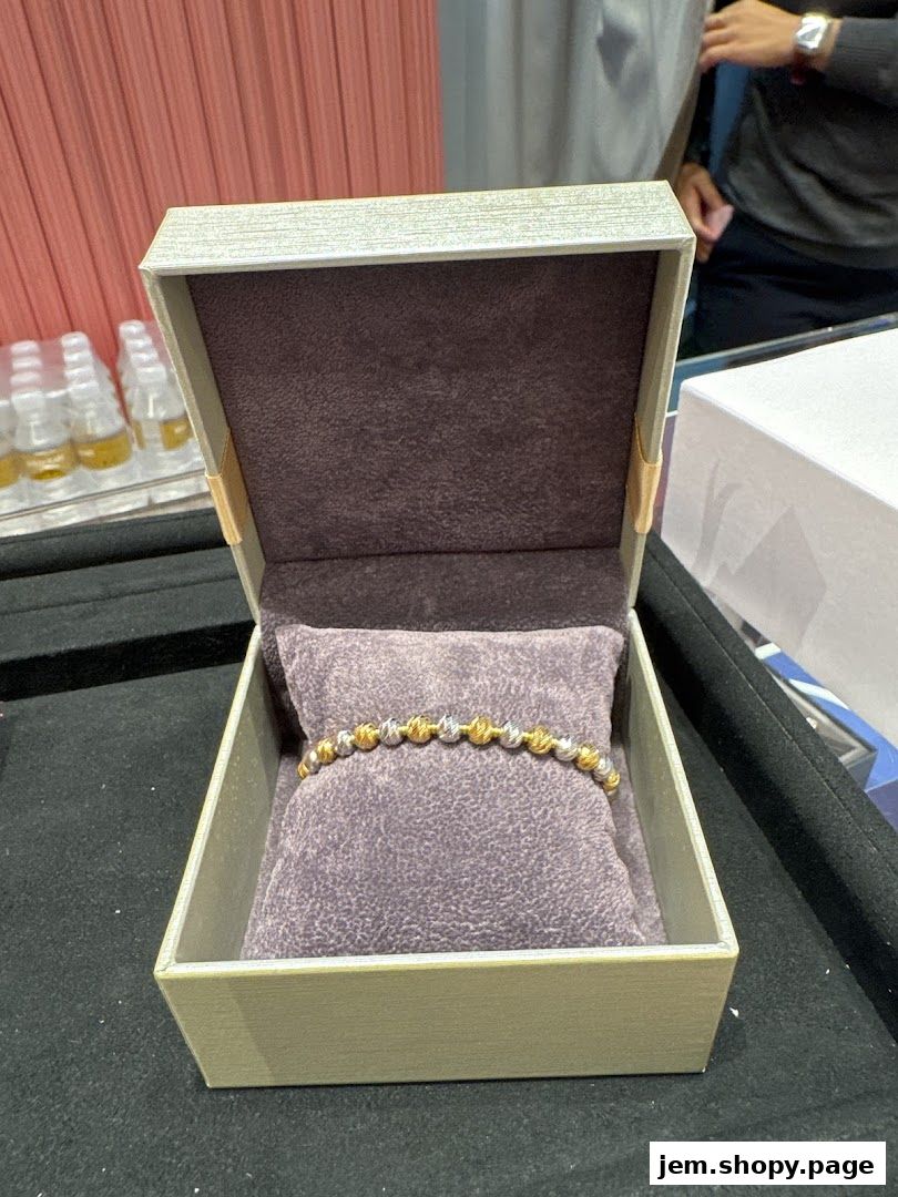 A gold and silver beaded bracelet displayed in an open jewelry box.