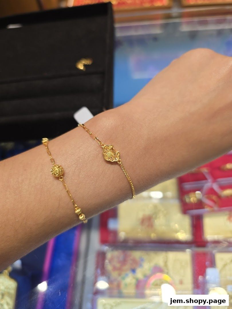 Close-up of two delicate gold bracelets on a person's wrist in a jewelry store.