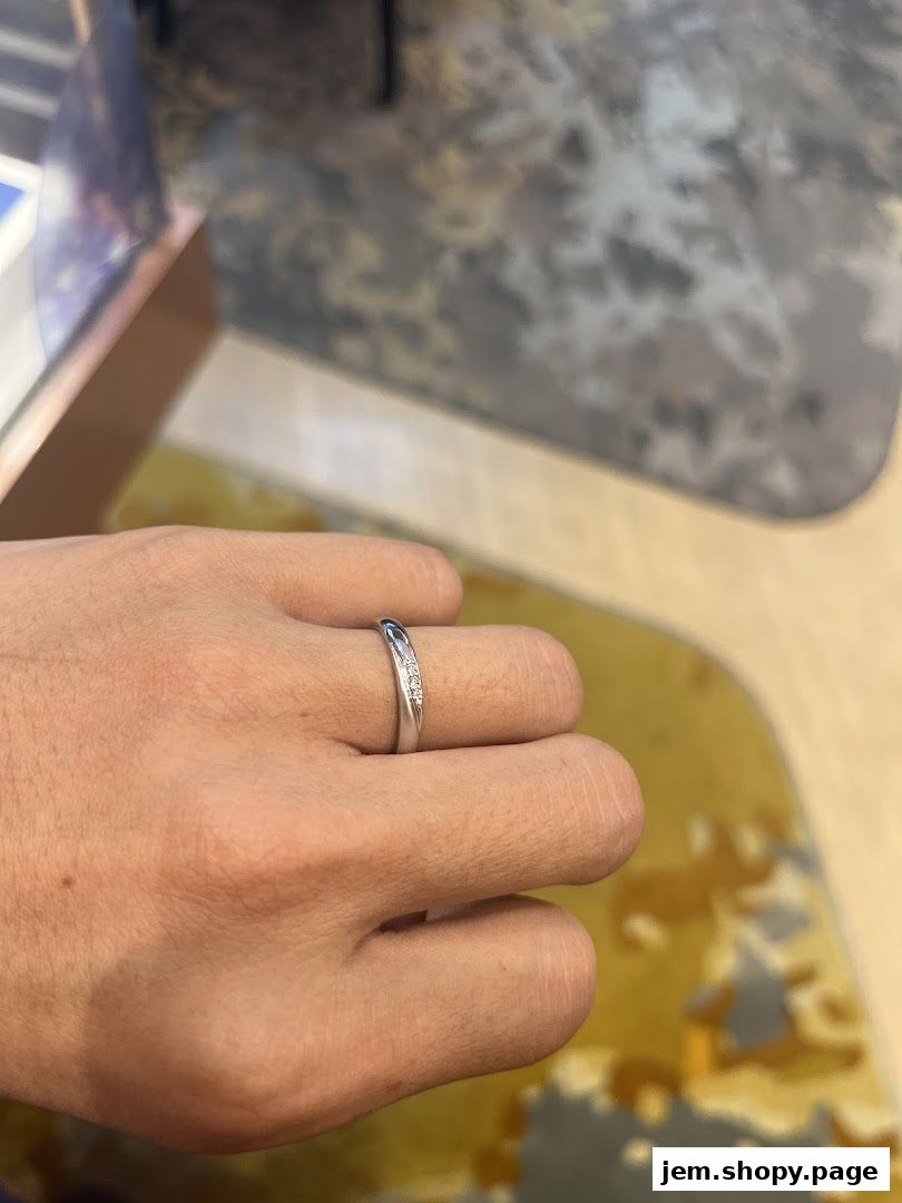 A close-up shot of a hand wearing a delicate diamond-accented ring.