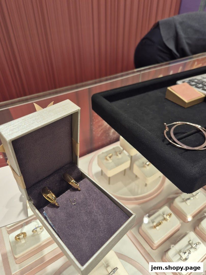 A display case filled with elegant gold and silver jewelry, including earrings and rings.