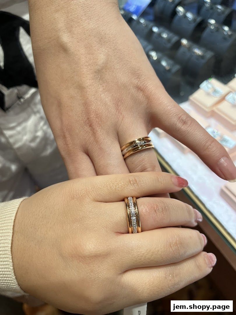 Close-up of two hands wearing elegant gold rings with diamonds.