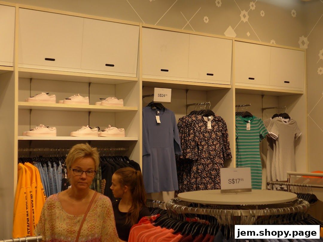 Interior view of an H&M store showcasing clothing and shoes on display shelves.