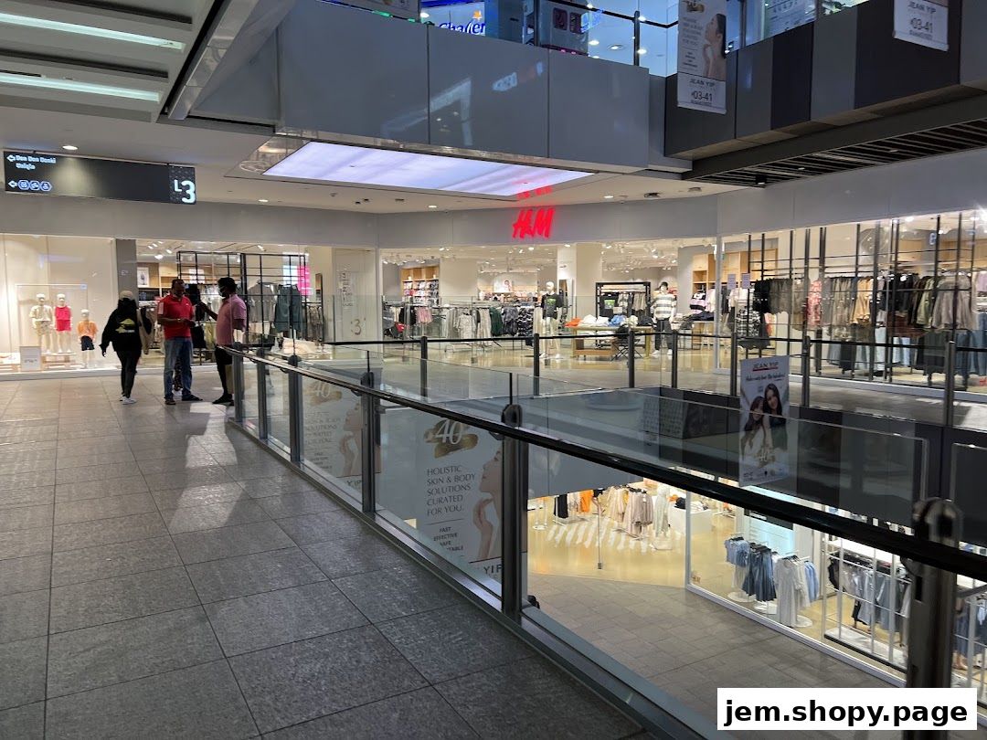 Interior view of an H&M store with clothing displays and shoppers.