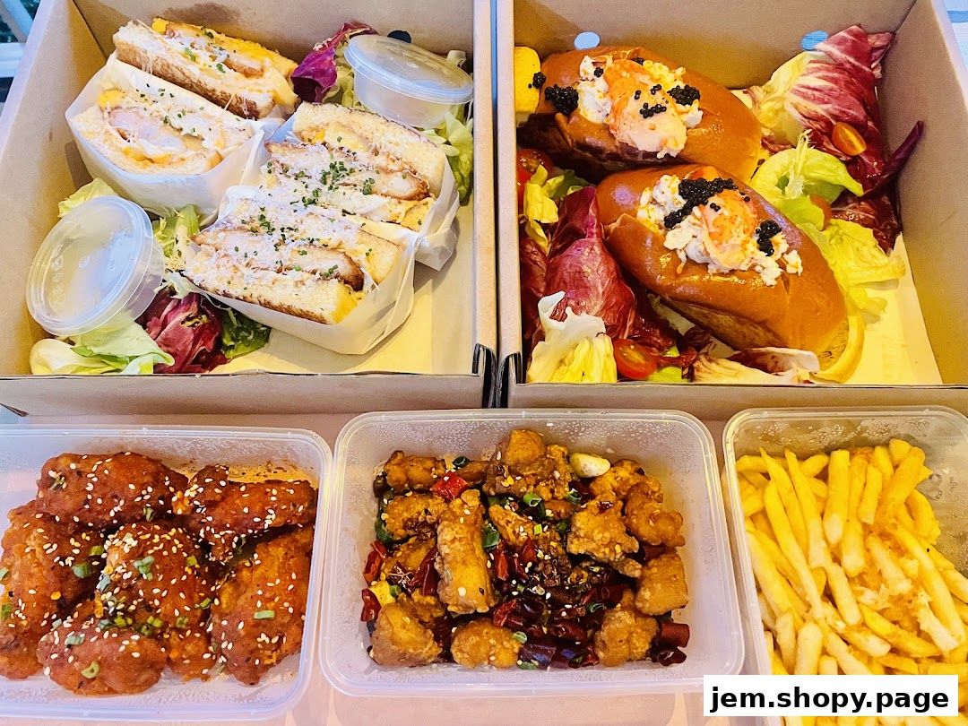 A variety of delicious takeout food including sandwiches, lobster rolls, fried chicken, and fries.