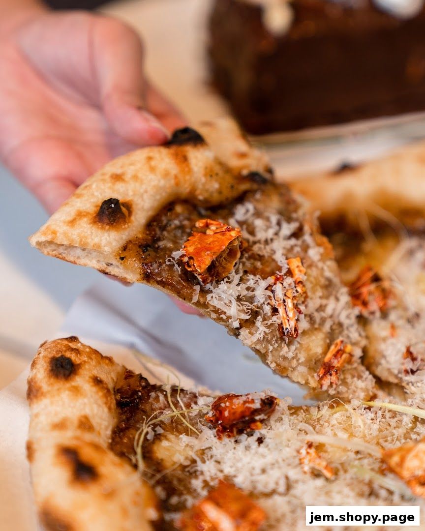 A hand holds a slice of gourmet pizza topped with cheese and red ingredients.