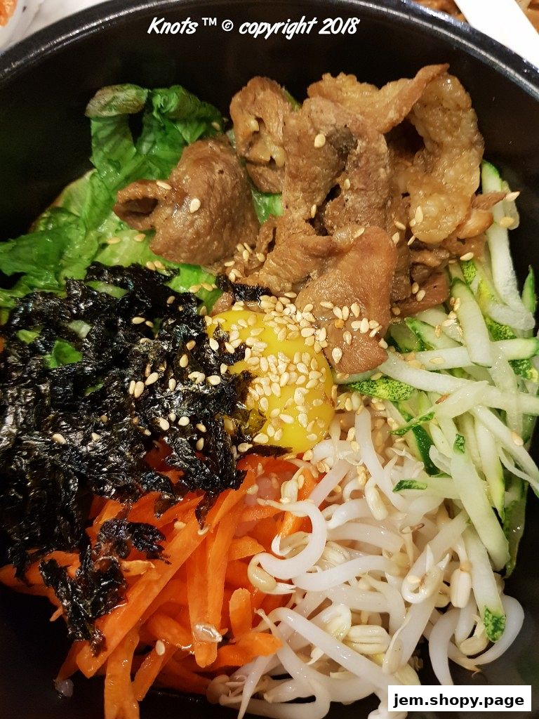 A close-up shot of a delicious Korean bibimbap dish with fresh vegetables and meat.