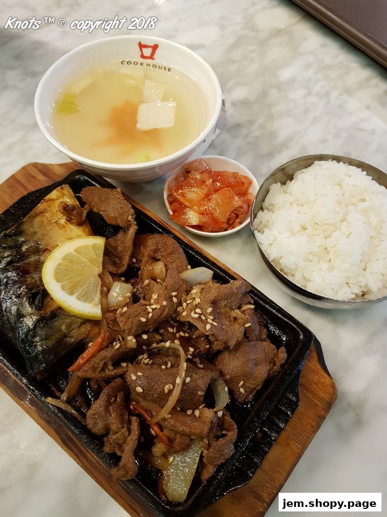 A sizzling Korean meal featuring grilled meat, fish, rice, soup, and kimchi.