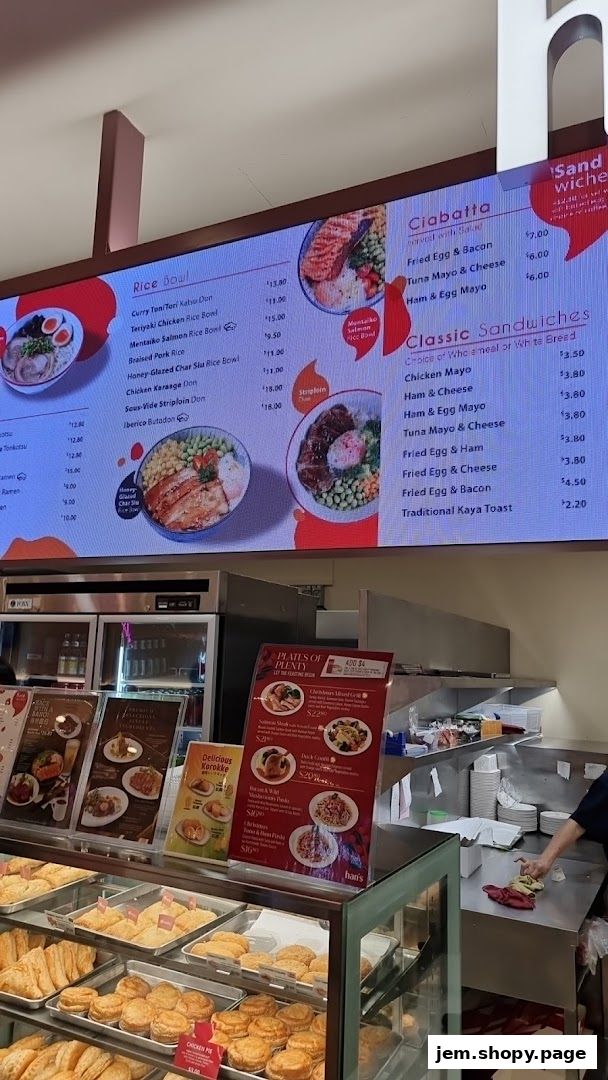 A digital menu board displaying various rice bowls, ciabatta, and classic sandwiches with prices.