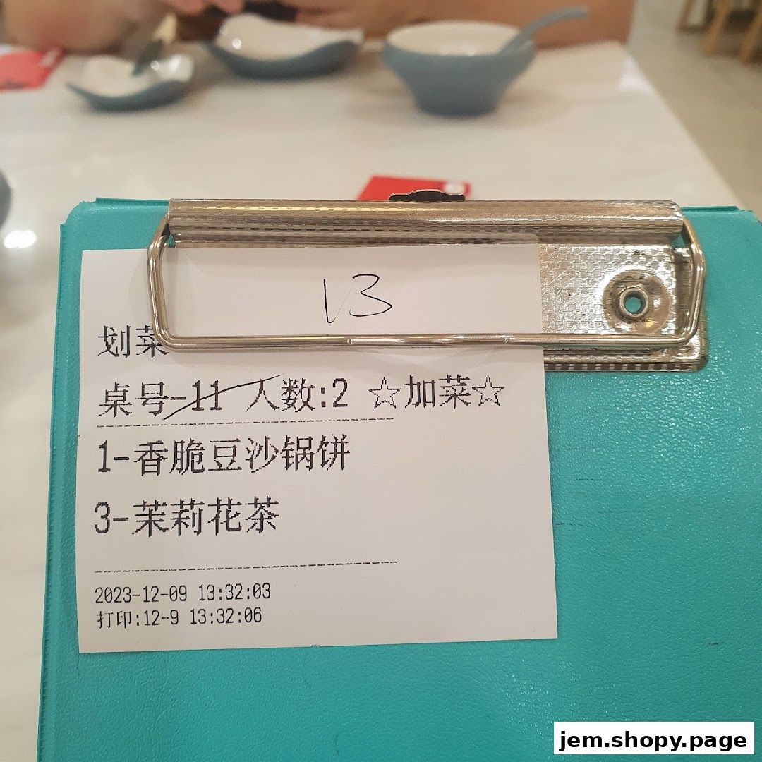 A close-up of a restaurant order slip with table number, items, and time.