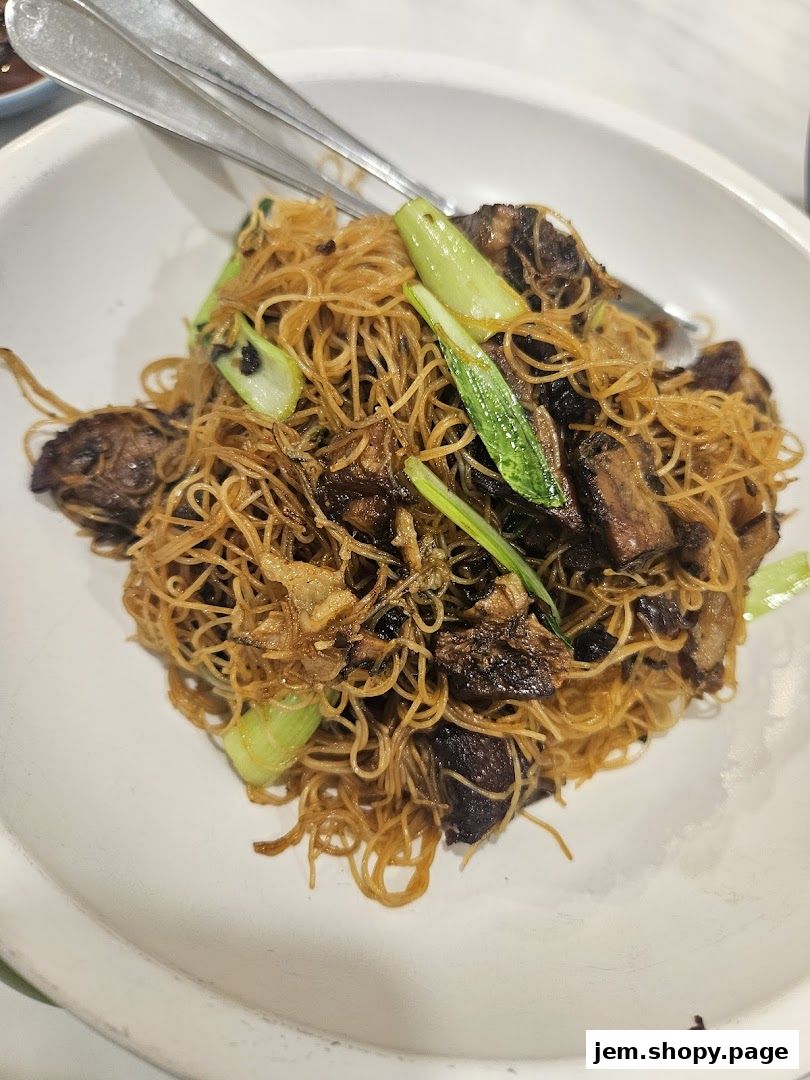 A close-up shot of a delicious plate of stir-fried noodles with meat and vegetables.