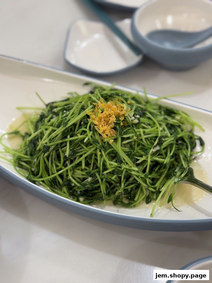 A plate of stir-fried pea shoots with garlic and ginger.