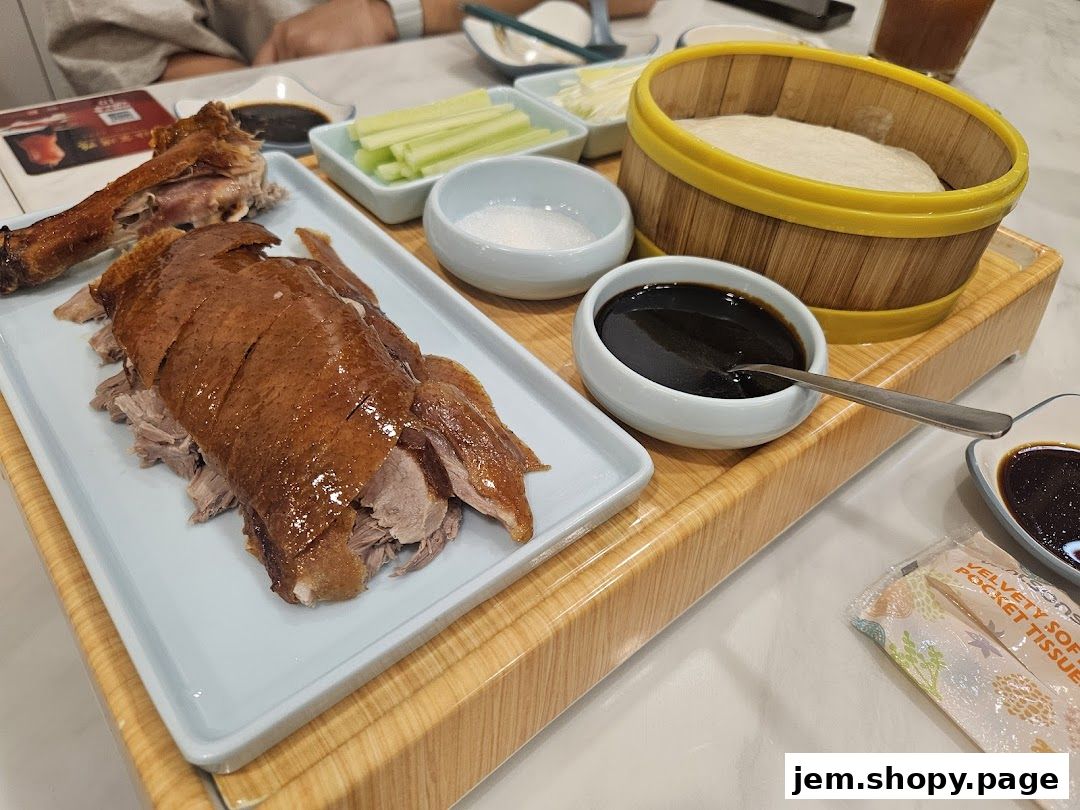 A platter of Peking duck with accompaniments like pancakes, sauce, and scallions.