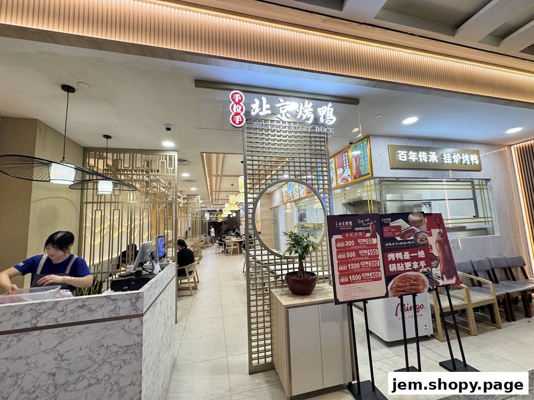 The entrance of Hand in Hand Peking Duck restaurant with a display of menu boards outside.