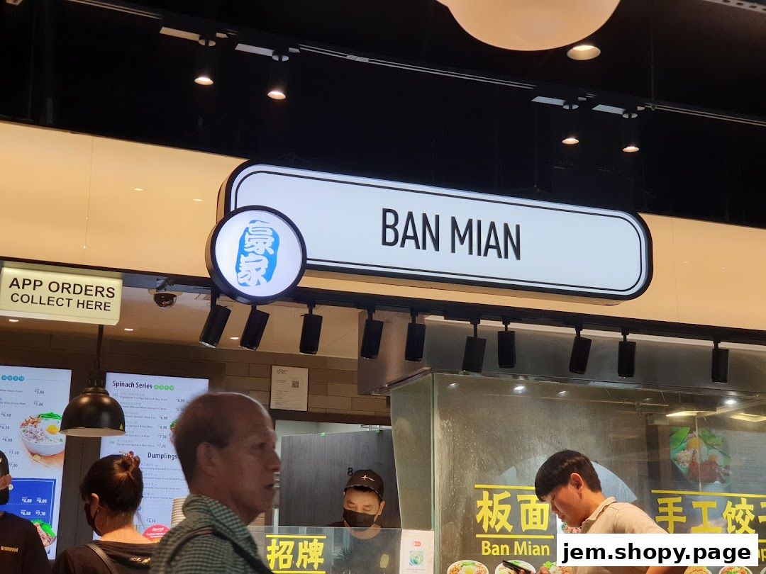 A sign for 'BAN MIAN' above a food stall with customers ordering.