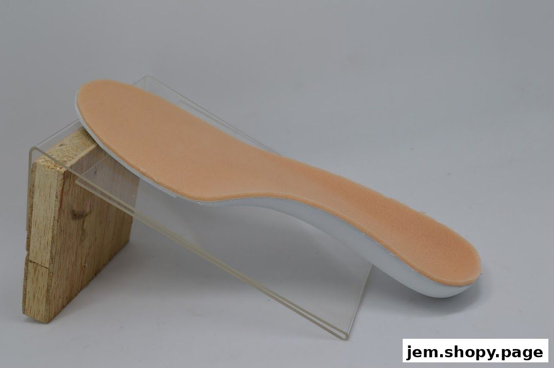 A close-up of a beige and white shoe insole displayed on a stand.