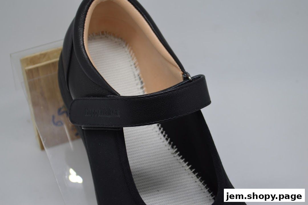 Close-up of a black Happy Walker shoe with a velcro strap and white sole.