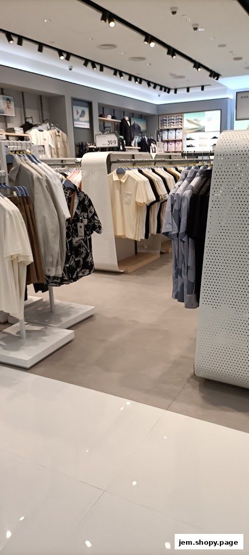 Interior view of a clothing store with racks of men's shirts and apparel.
