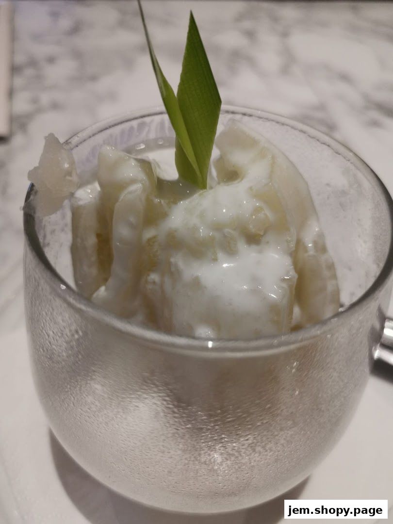 A refreshing dessert served in a glass bowl, garnished with a green leaf.