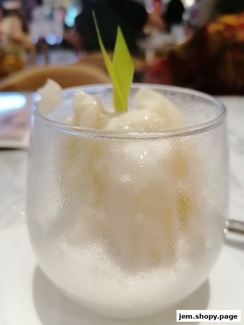 A refreshing dessert served in a frosted glass with a green garnish.