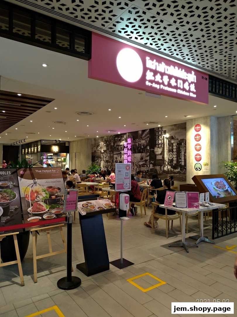 Interior view of a restaurant with seating, menus, and a prominent sign.