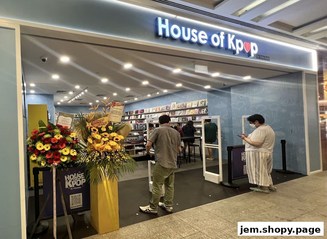 The entrance of House of Kpop store, featuring merchandise displays and floral arrangements.