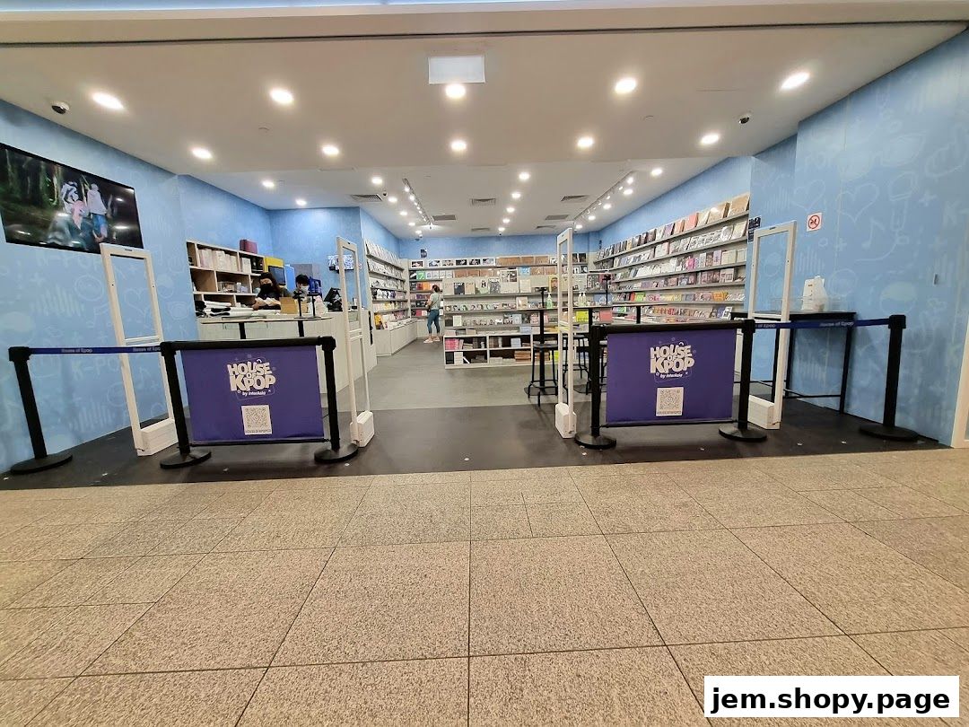 Entrance to House of Kpop store with merchandise displays and a welcome banner.