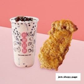 A cup of bubble tea and a piece of fried chicken on a pink background.